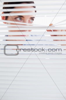 Curious brunette Woman peeking out of a window