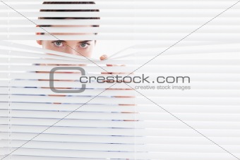 Curious cute Woman peeking out of a window