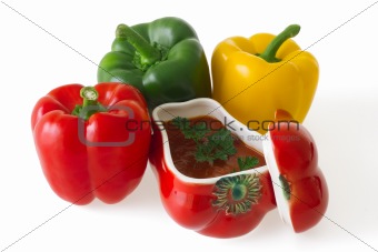 Red, green and yellow bell peppers with red ceramic ornament