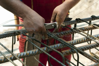Construction worker ties reinforcing steel