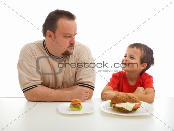 Man and young boy rival over food