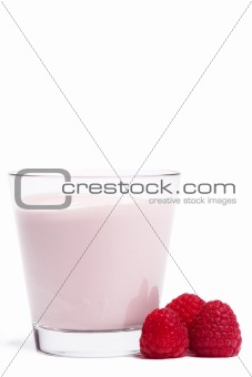 some raspberries near a milkshake