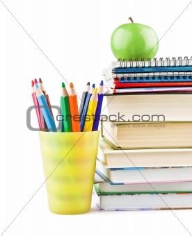 Textbooks and notebooks next to the pencils and green apple on top