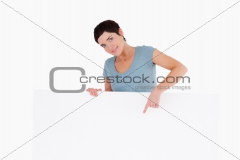 Smiling woman pointing at something on a panel