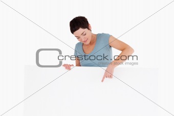 Brunette woman pointing at something on a panel