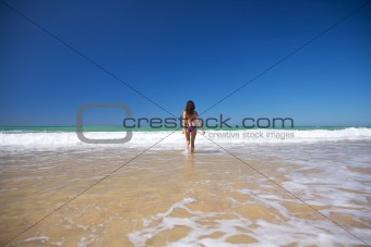 woman running to the ocean at Conil beach