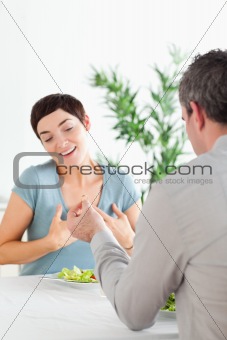 Man proposing to his amazed girlfriend during dinner