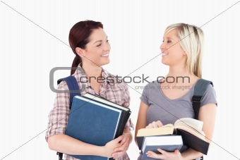 Students with books looking at each other
