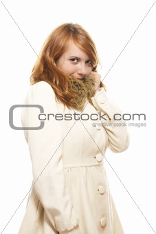 young redhead woman covering her face in fawn winter coat