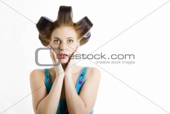 Young beautiful surprised woman in blue shirt with curlers