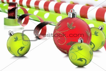 Rolls of gift wrapping paper and ribbon with red and green christmas baubles