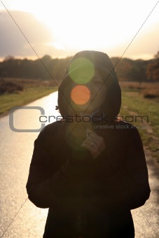 Asian woman stands in morning sunshine