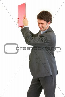 Angry businessman throwing folder
