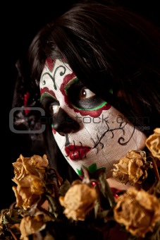 Portrait of Sugar skull girl with dead roses 