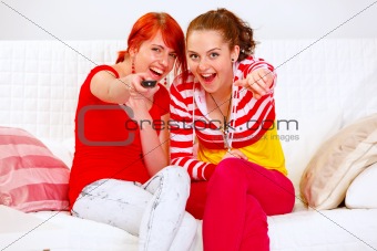 Smiling girlfriends watching TV
