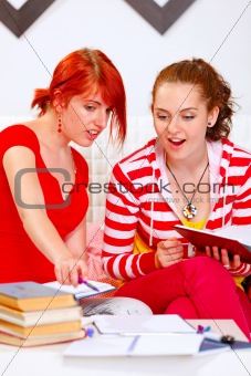Girl helping her girlfriend studying
