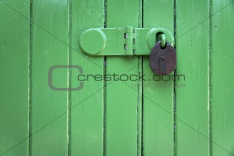 green wooden door rusty padlock