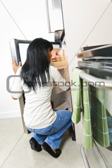 Young woman looking in refrigerator