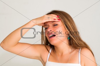 young woman with headache holding her hand to the head 