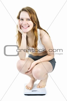 Smiling young girl on bathroom scale