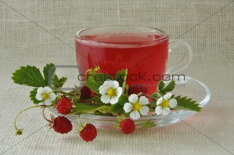 Fruit tea in a glass cup with berries and colors