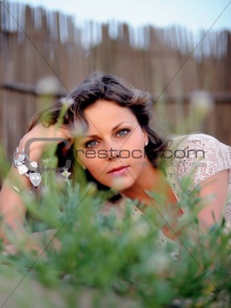 Young pretty summer woman lying on the grass