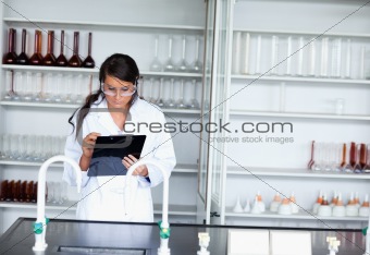 Serious female scientist writing on a clipboard
