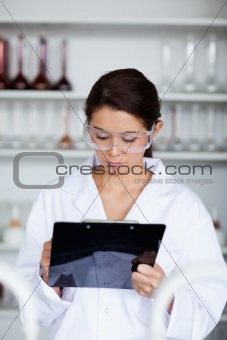 Portrait of a scientist writing on a clipboard