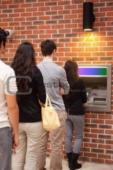 Portrait of people queuing to withdraw cash