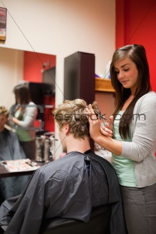 Portrait of a focused woman cutting a man's hair