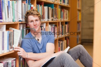 Handsome student picking a book