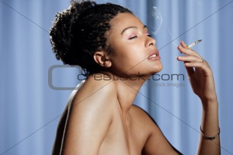 Beautiful sensual and naked woman enjoying a cigarette