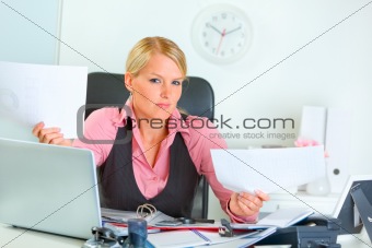 Confused business woman at office desk
