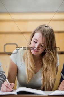 Portrait of a cute student holding a pen