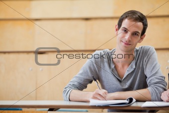Portrait of a male student writing on a notepad