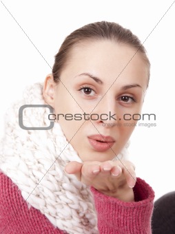 Beautiful woman in winter scarf blow kisses