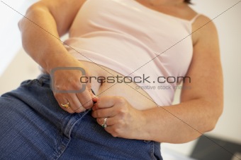 Overweight Woman Trying To Fasten Trousers