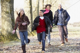 Family Running Through Autumn Countryside