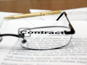 Glasses and pen on the contract papers