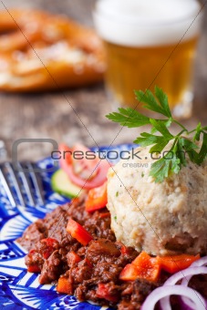 goulash with dumpling on a blue plate