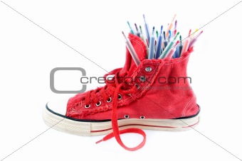 Coloured pens in sneakers, a white background.
