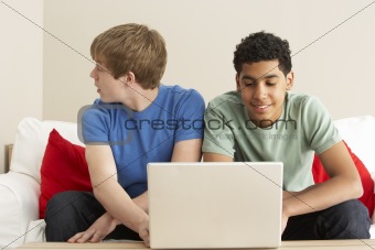 Two Boys Using Laptop At Home