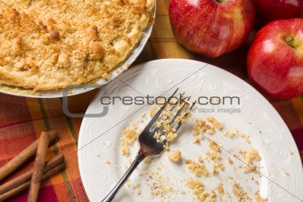 Overhead Abstract of Apple Pie, Empty Plate with Remaining Crumbs and Fork.
