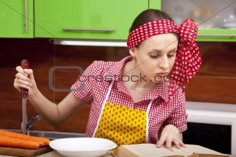 Woman in the kitchen with knife recipe book
