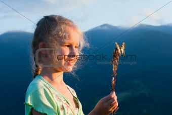girl and butterfly in sunset mountain