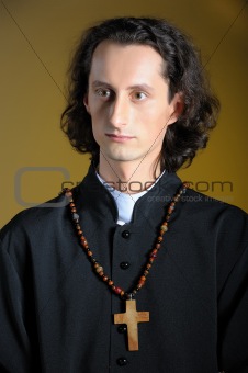 conceptual portrait of Praying priest with wooden cross praying.