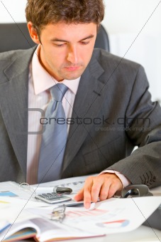 Serious modern businessman working with documents
