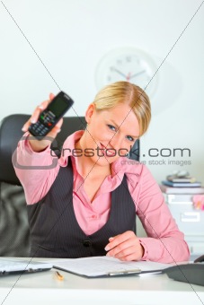 Cheerful modern female manager showing mobile phone
