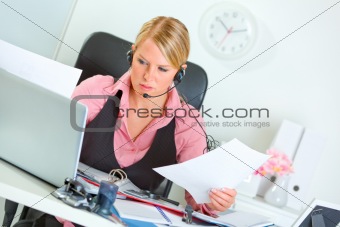 Confused female manager with headset at working place
