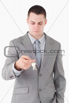 Portrait of a young businessman looking at a set of keys